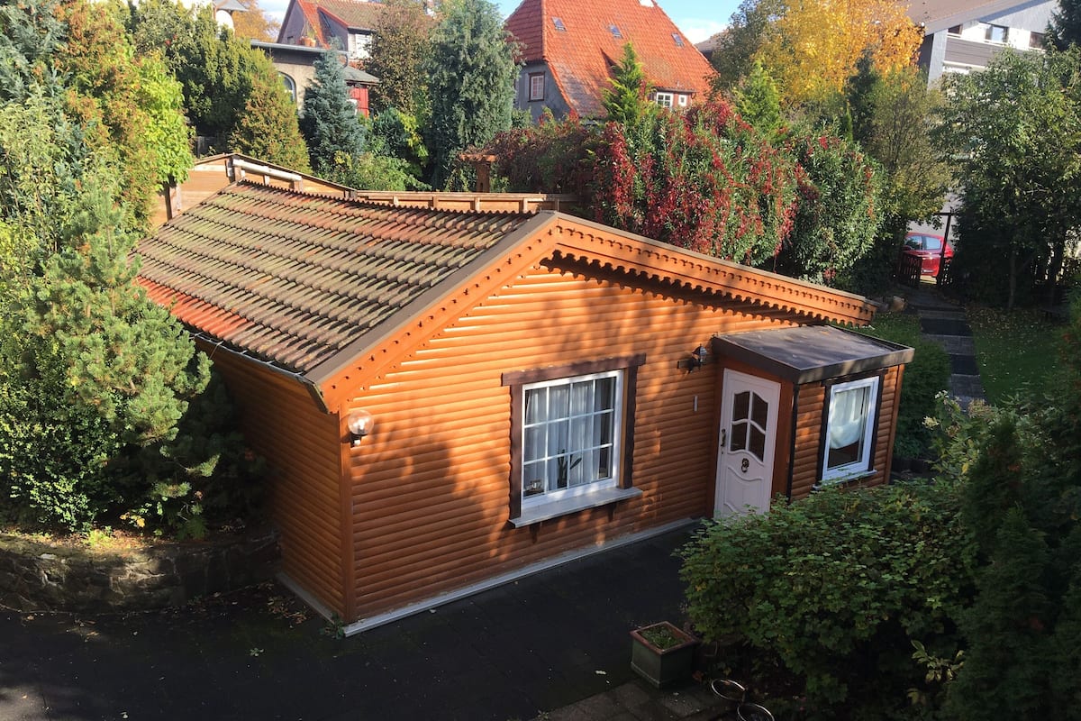 A small wooden cabin with a sloped roof, a single window, and a door.