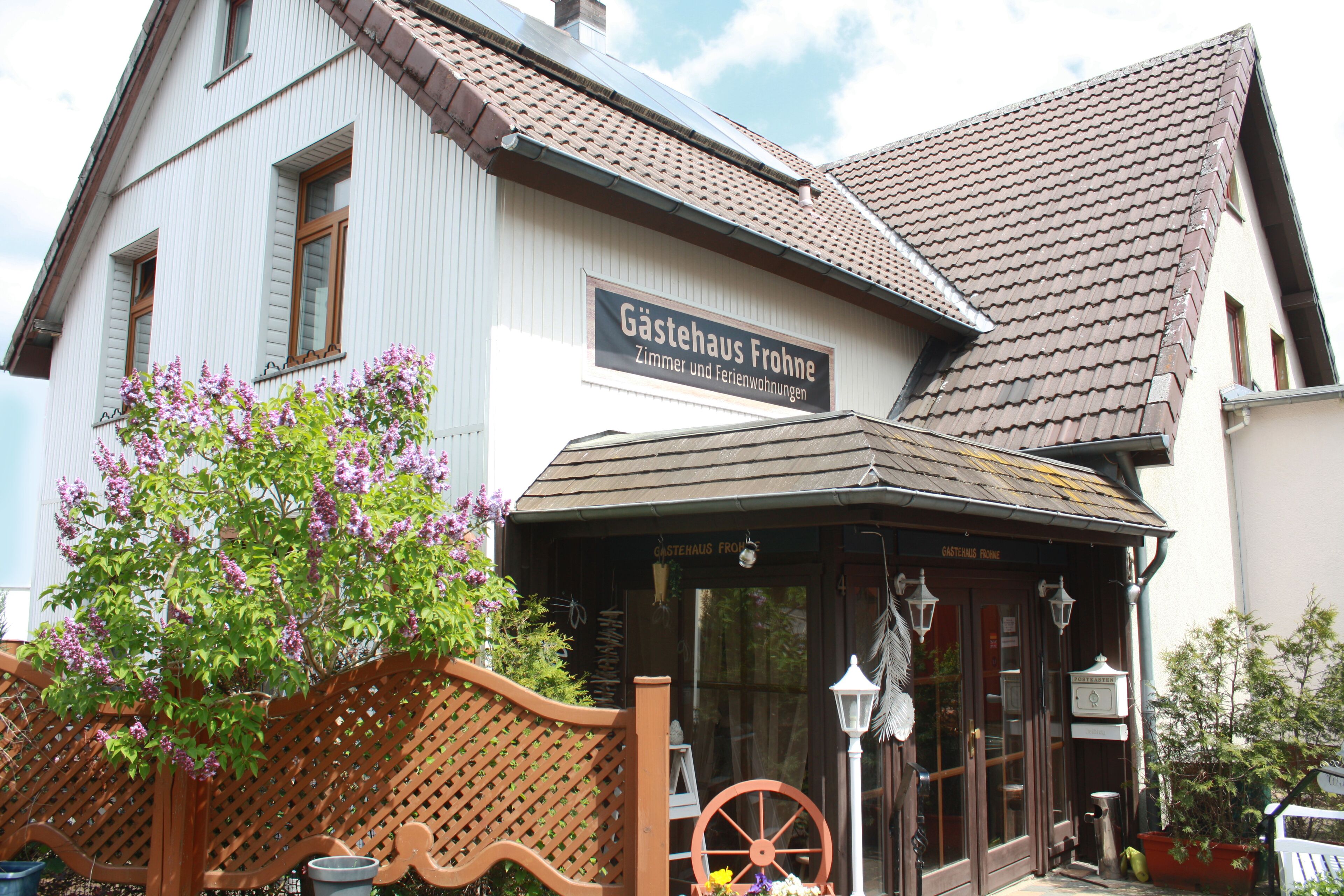 A traditional building with a sign reading "Gästehaus Frohne Zimmer und Ferienwohnungen".