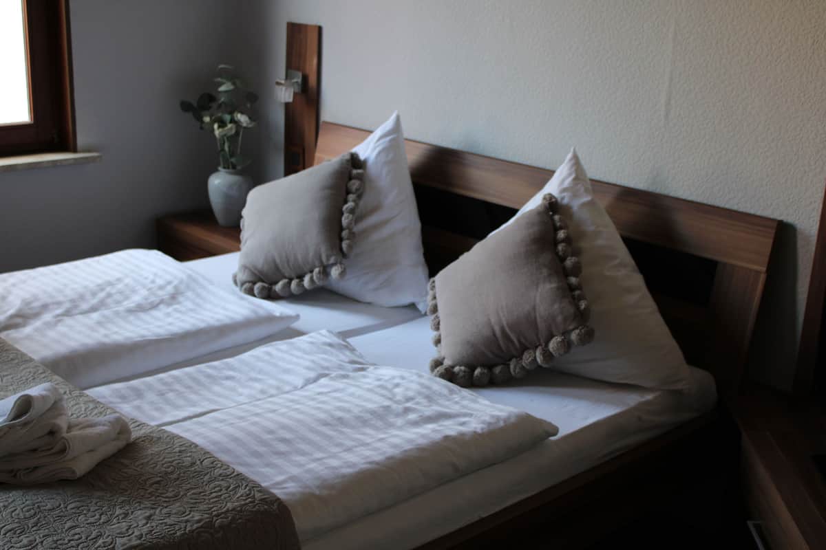 A neatly made bed with two pillows and a folded blanket.