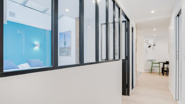 A modern interior with a staircase, a blue accent wall, and a dining area with chairs and a table. - Hedonist House - Design Loft Design in  Heart of Paris ! (Paris)