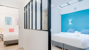A modern hotel room with a large bed, a separate seating area, and a view of the city. - Hedonist House - Design Loft Design in  Heart of Paris ! (Paris)