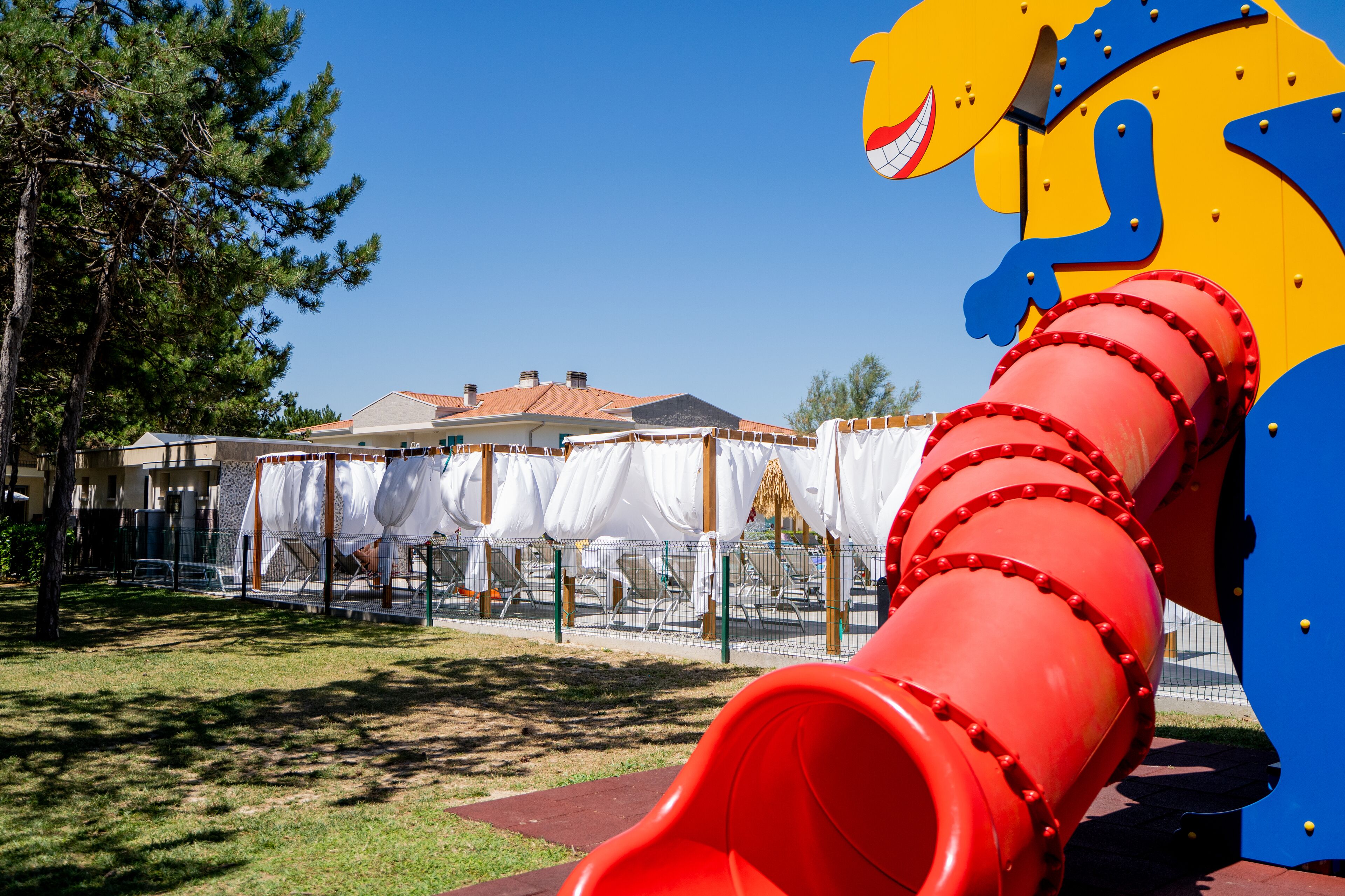 A playground with a red slide and a yellow and blue structure.