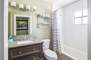 Bathtub, hair dryer, towels, shampoo