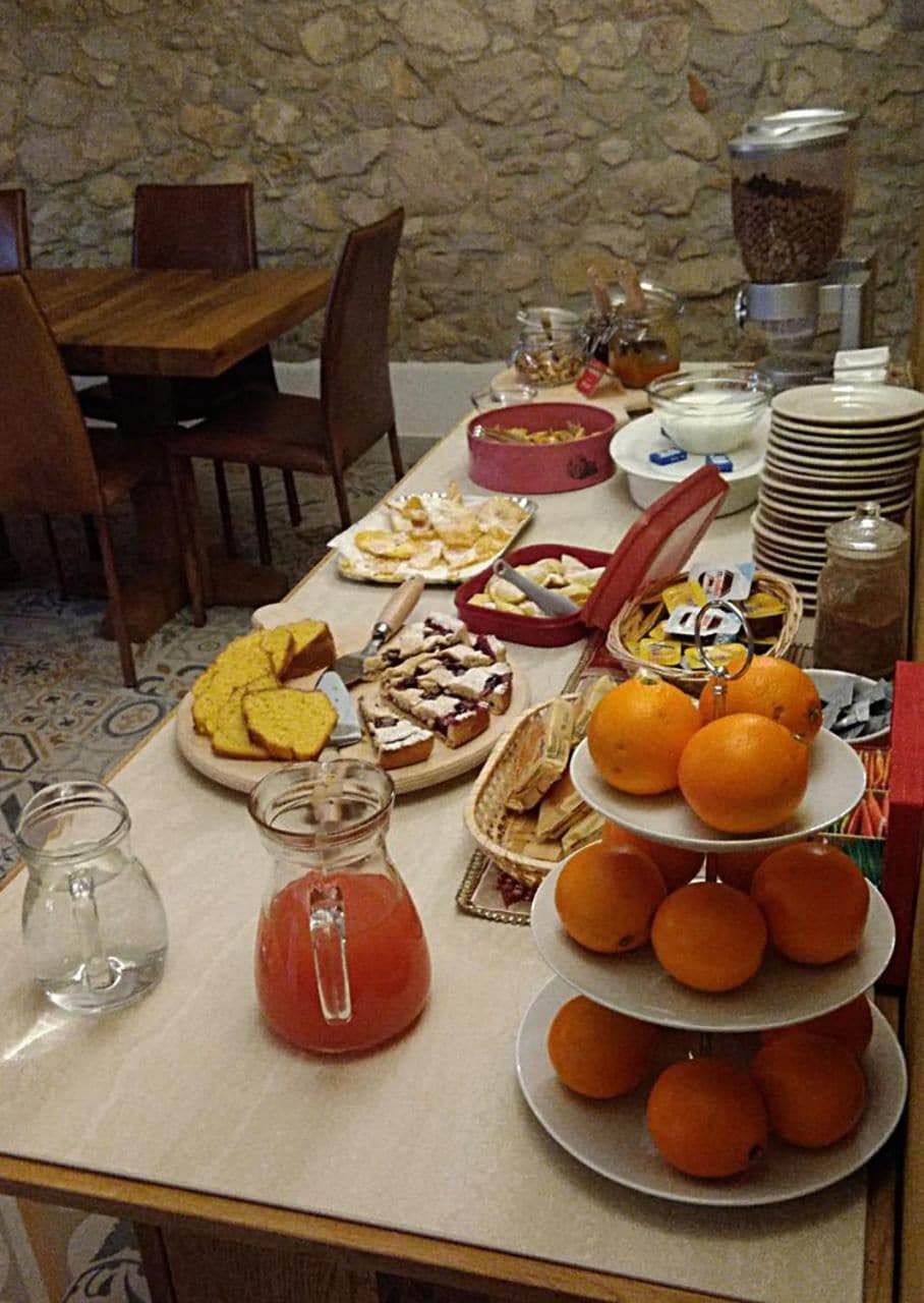 Un bufé de desayuno con diversas opciones de comida y una exhibición de frutas.