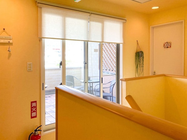 Quarto de hotel com porta de vidro deslizante que dá para uma área de estar externa.
