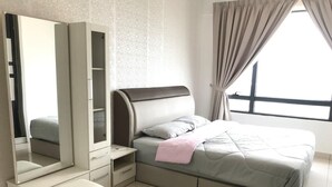 Une chambre à coucher comprenant un lit, une coiffeuse avec un miroir, une table de chevet et une fenêtre avec des rideaux.