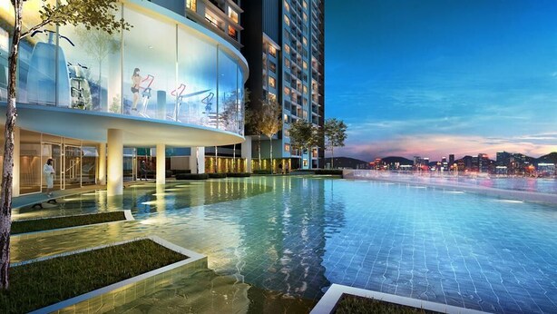 Un hôtel moderne doté d’une grande piscine extérieure, d’une façade en verre et offrant une vue sur les toits de la ville au crépuscule.