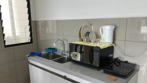 Une cuisine équipée d’un évier, d’un four à micro-ondes, d’une bouilloire et d’une machine à café.