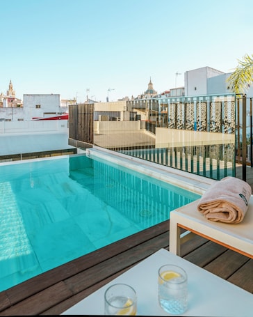 Una piscina al aire libre, sillones reclinables de piscina