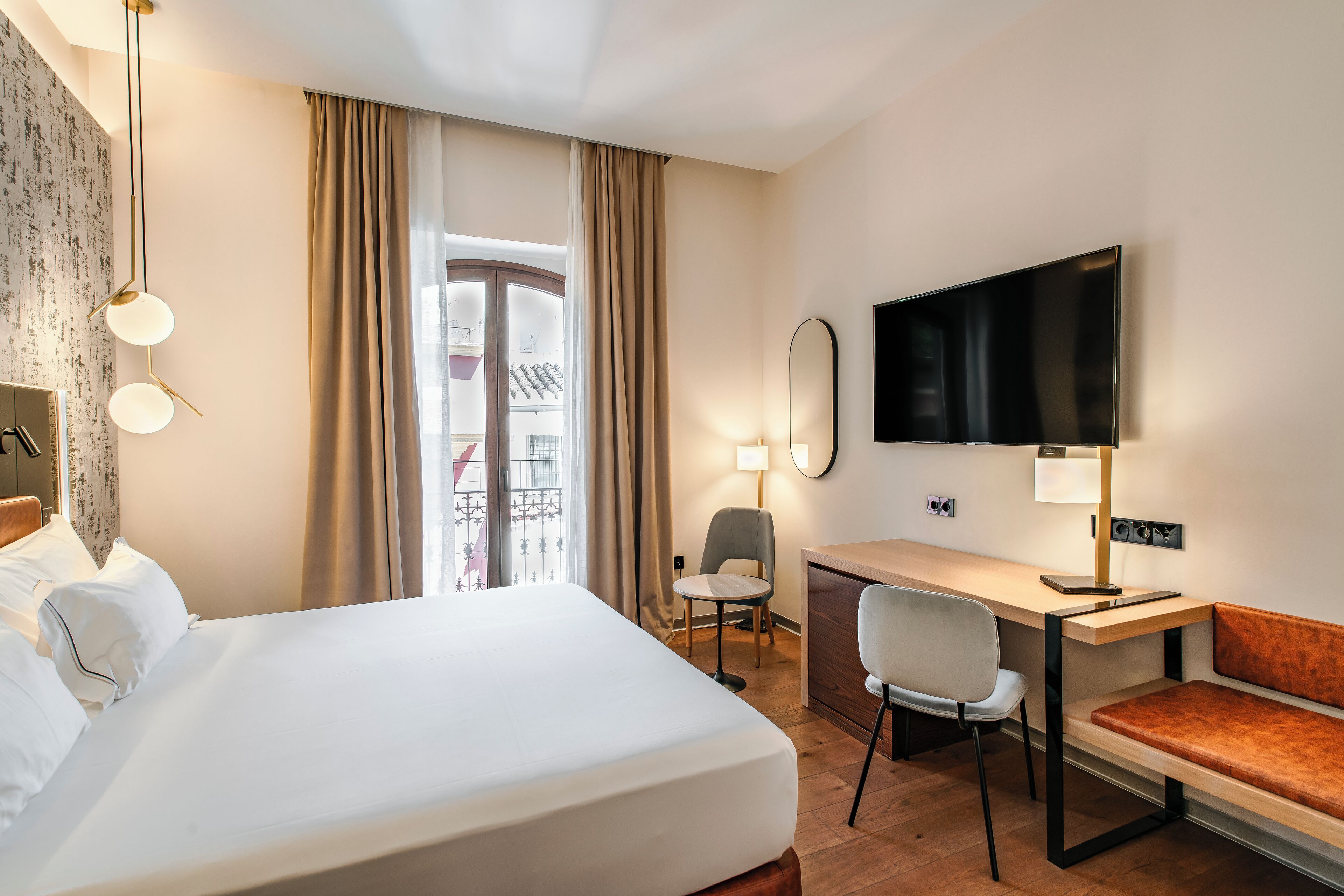 Una habitación de hotel con cama, escritorio, silla y televisión.