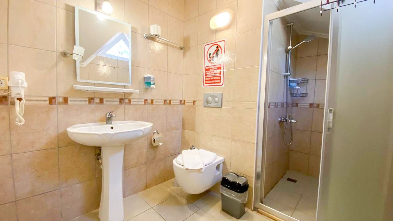 Un baño con lavamanos, inodoro y ducha.