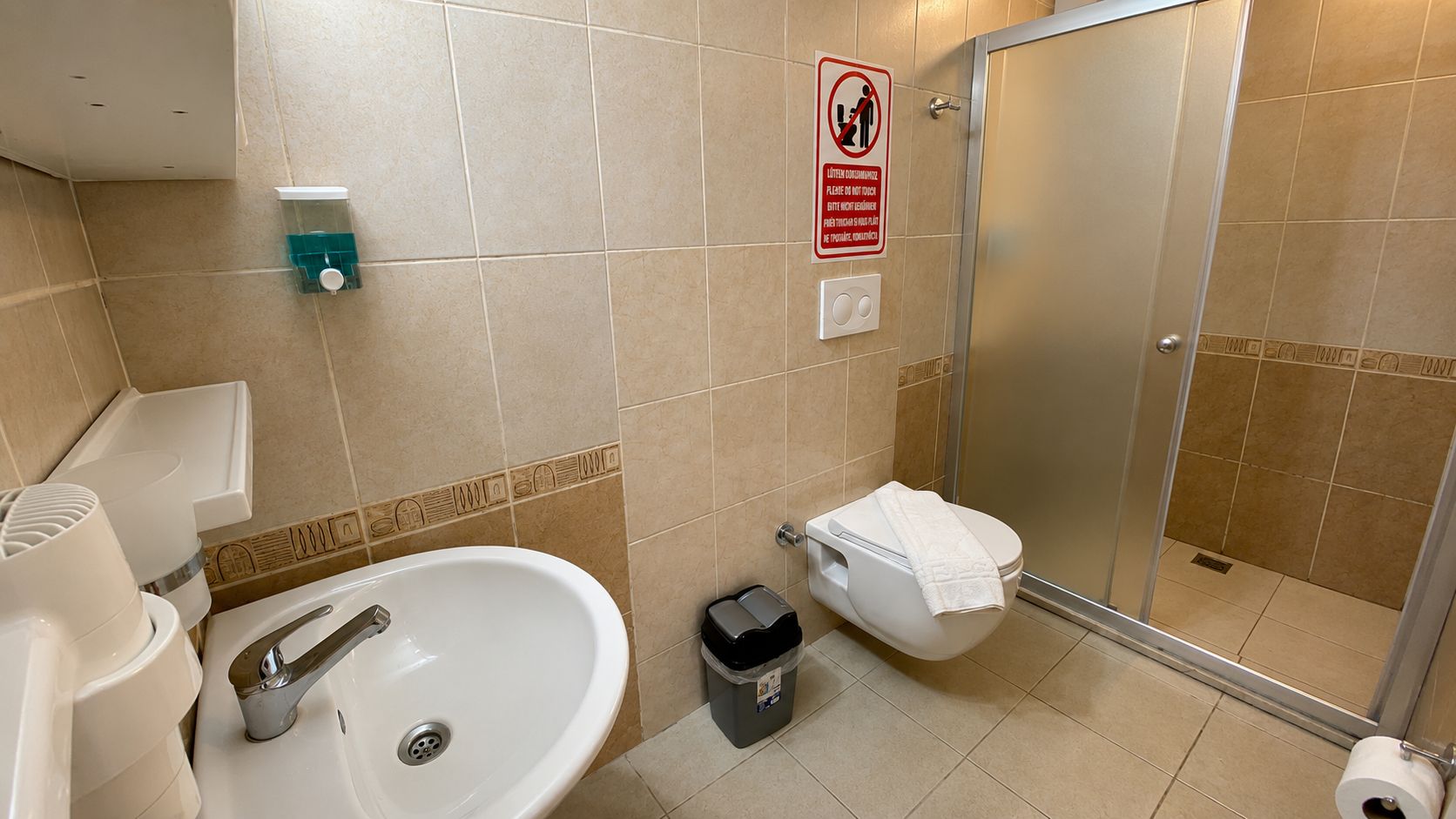 Un baño con lavamanos, inodoro y ducha.