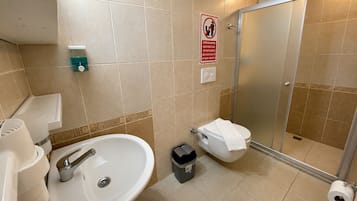Un baño con lavamanos, inodoro y ducha.