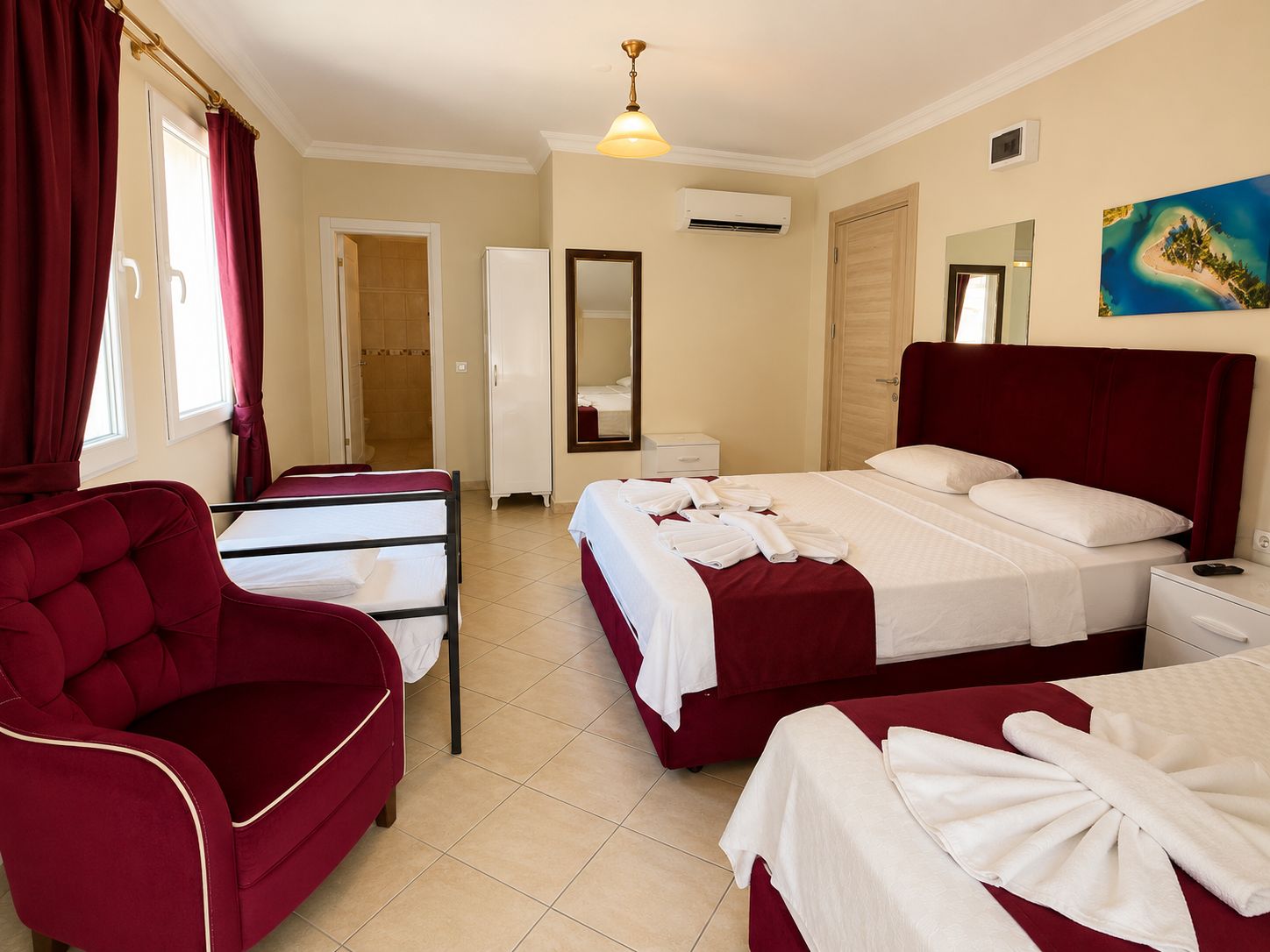 A hotel room with a bed, a chair, a wardrobe, and a bathroom.