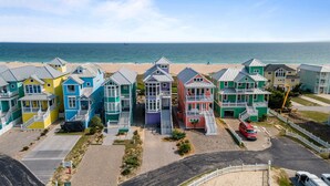 Une rangée de maisons de plage colorées, toutes offrant une vue sur l’océan.