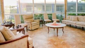 A sunlit room with a sofa, chairs, and a coffee table. - Casa Bakab by Rotamundos (Mérida)