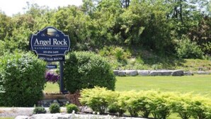 Een bord voor Angel Rock Waterfront Cottages met prijzen voor het hele jaar.