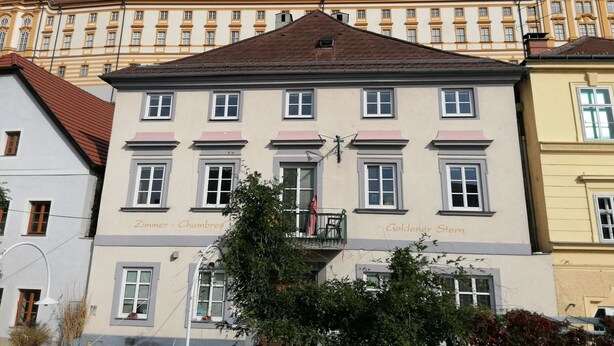 Um edifício histórico com várias janelas e uma entrada central.