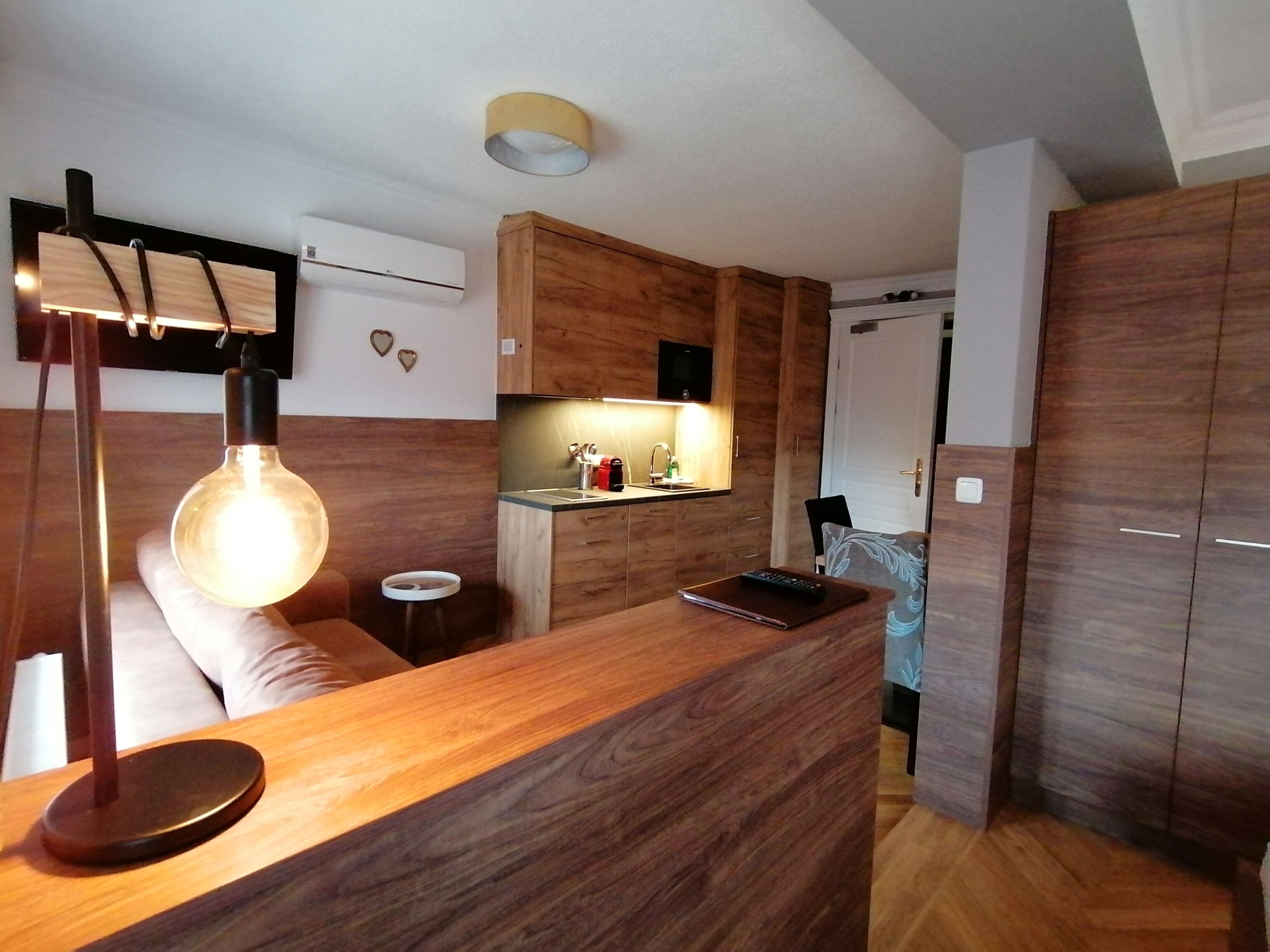 Een moderne keuken met houten kastjes, een inbouwfornuis en een hanglamp.