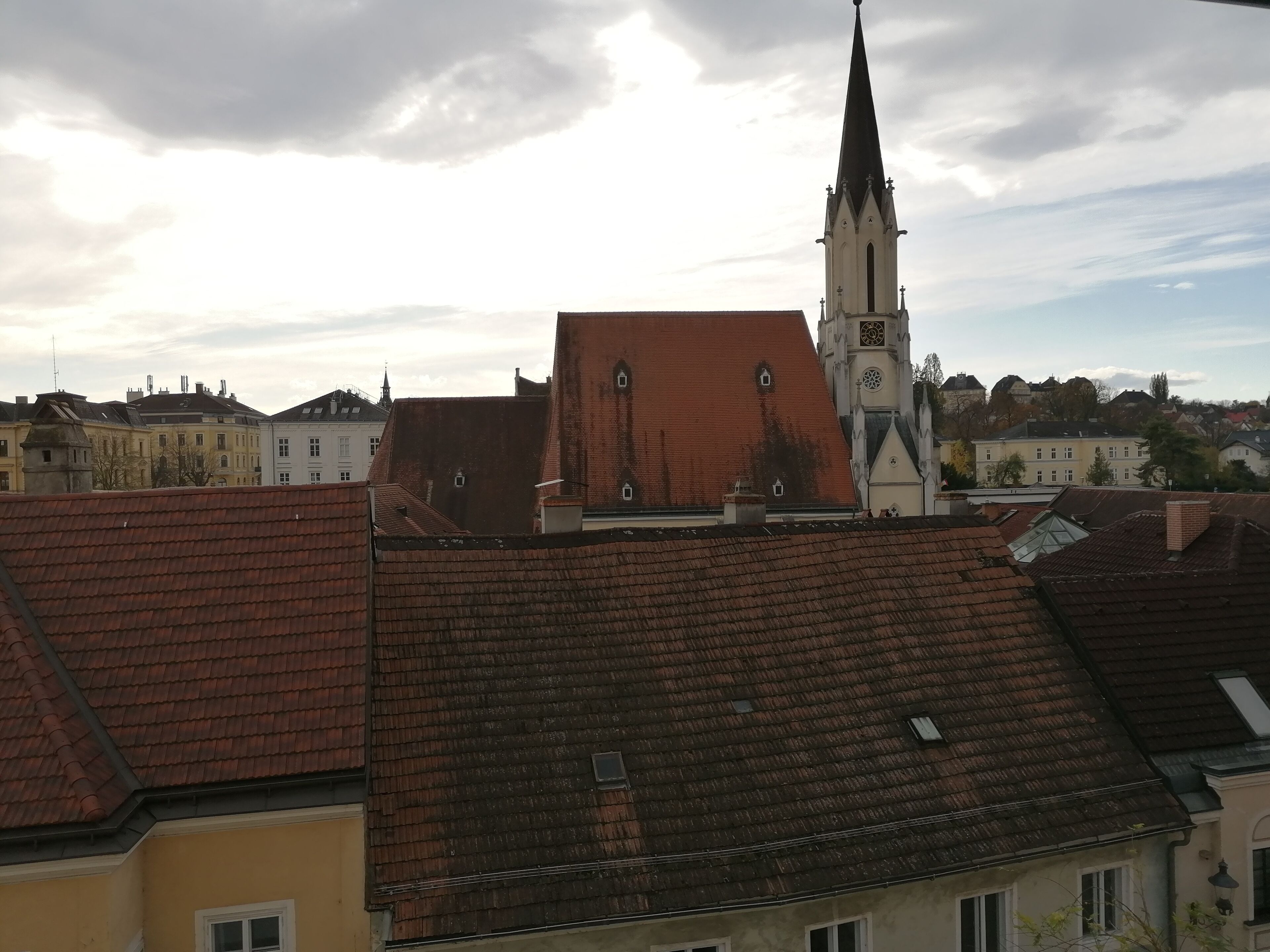 Une vue d’une ville avec un clocher d’église imposant et les bâtiments environnants.