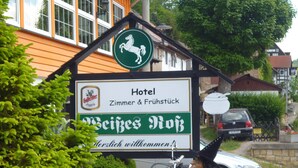 Placa de hotel com um logotipo de cavalo, indicando que pode ser um estabelecimento tradicional ou histórico.