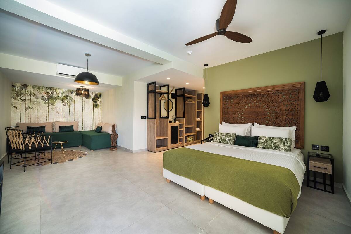 A spacious bedroom with a large bed, a ceiling fan, a wooden headboard, and a built-in wardrobe.