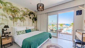 A bedroom with a bed, a nightstand, a lamp, a large window with a view of a pool and palm trees, and a ceiling light.