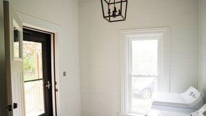 A laundry room with a washer and dryer, a door with a window, and a hanging light fixture. - Fall color tours!-Awesome Location! Luxury Farmhouse near Wineries & Orchards!! (Fennville)
