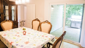 A dining room with a floral tablecloth, wooden chairs, and a chandelier. - Fall color tours!-Awesome Location! Luxury Farmhouse near Wineries & Orchards!! (Fennville)