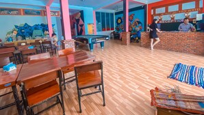 A reception area with a brick wall, a reception desk, and a colorful mural. - Vang Vieng Freedom View - Hostel (Vang Vieng)