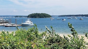 A marina with boats docked, a sandy beach, and a small island in the distance. - The SandDollar Suite - Private Deck with Gorgeous Views of Onset Beach (Onset)