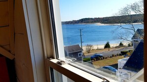 A view from a window overlooking a beach with a clear sky. - The SandDollar Suite - Private Deck with Gorgeous Views of Onset Beach (Onset)