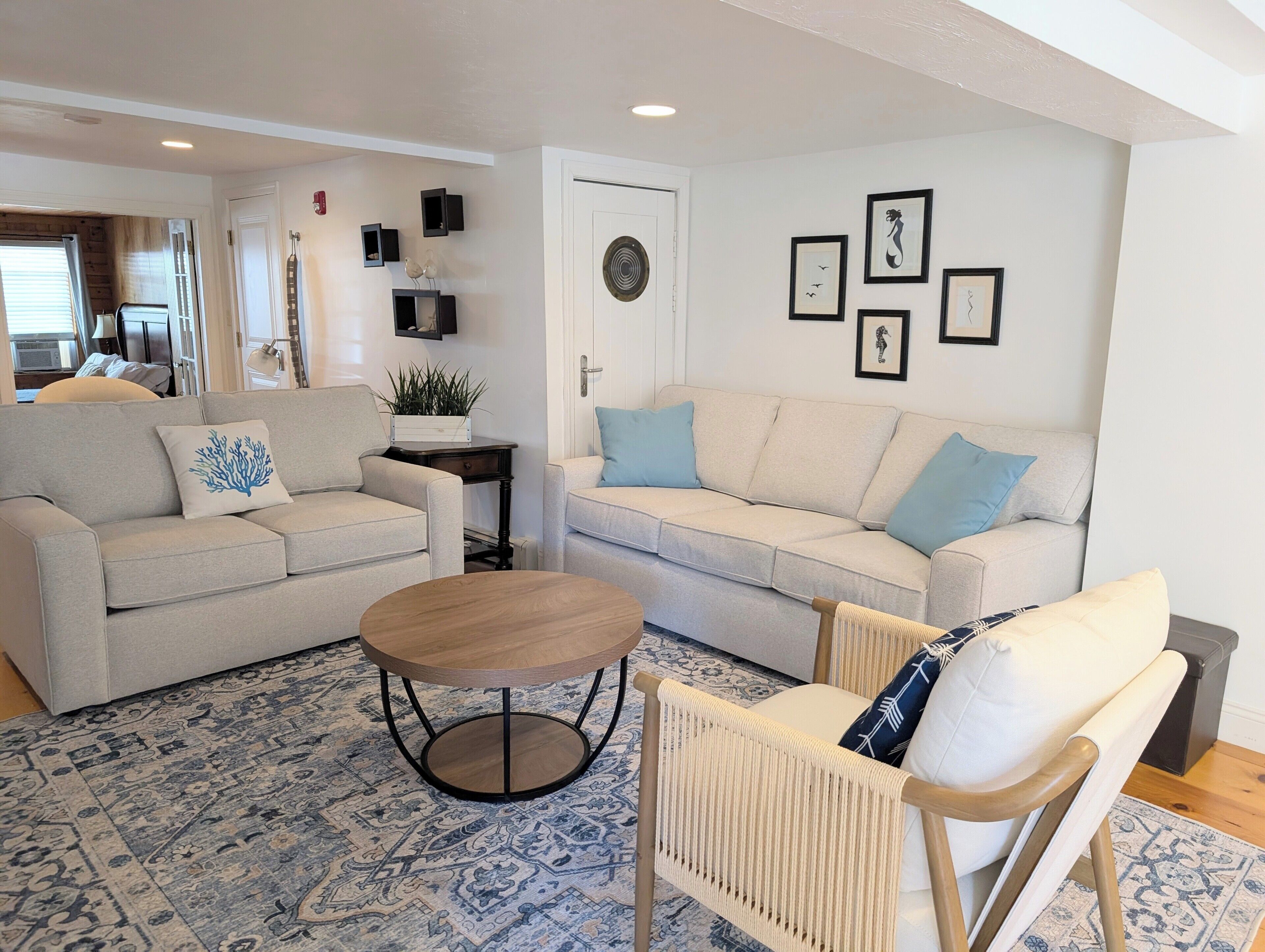 A living room with two sofas, a coffee table, and a patterned rug.