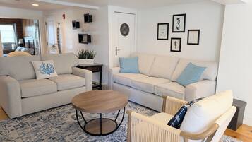 A living room with two sofas, a coffee table, and a patterned rug.