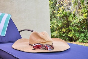 A straw hat and sunglasses on a blue lounge chair. - Charming Townhome | Gated Resort with Pool (Davenport)