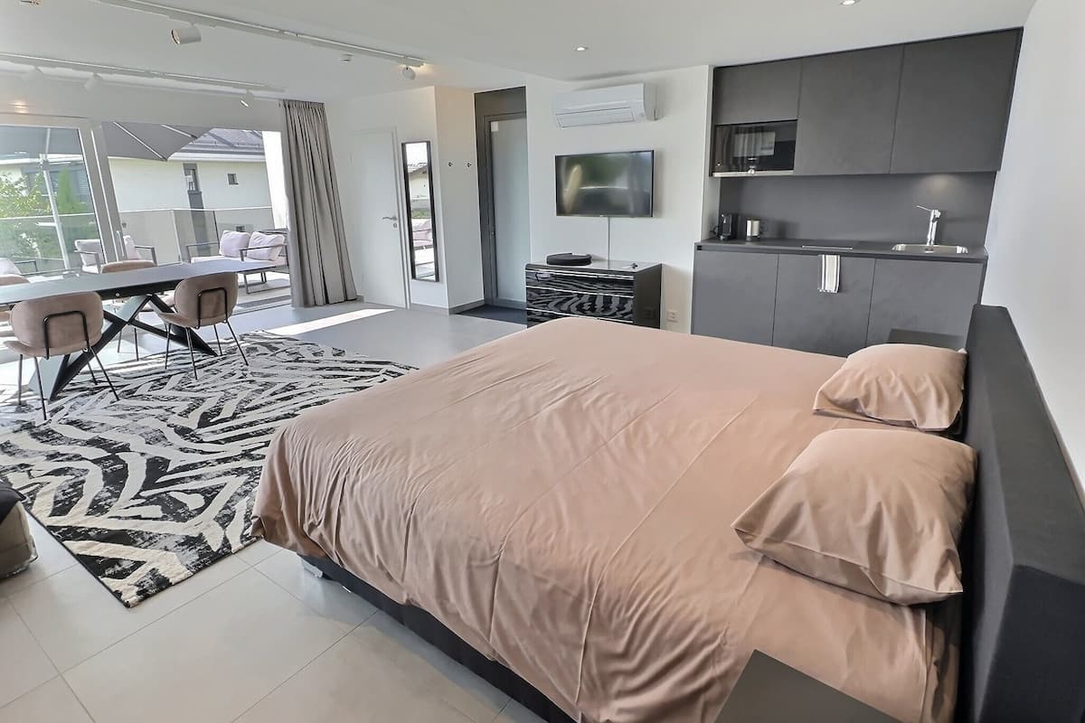 Un dormitorio moderno con una cama grande, un escritorio y un televisor.