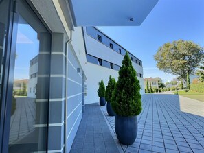 Stylish building with a flat roof and lush greenery along the entrance pathway.