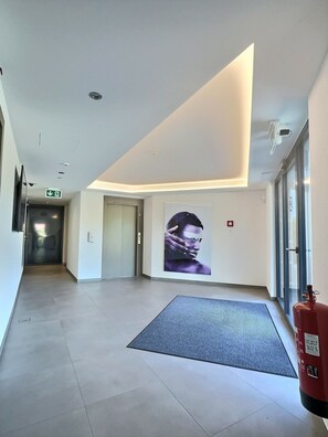 Enjoy a functional and accessible stay with a clear pathway to the elevator and safety features like a fire extinguisher and emergency exit.
