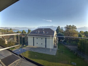 Enjoy a serene view of the water and mountains from this building's balcony, where you can relax or dine.