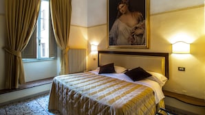 A hotel room with a large bed, a painting above the bed, and two wall-mounted lights. - Tourist House Duomo (Florence)