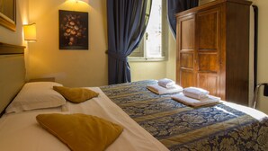 A hotel room with two beds, a wooden wardrobe, a painting on the wall, and a window with curtains. - Tourist House Duomo (Florence)