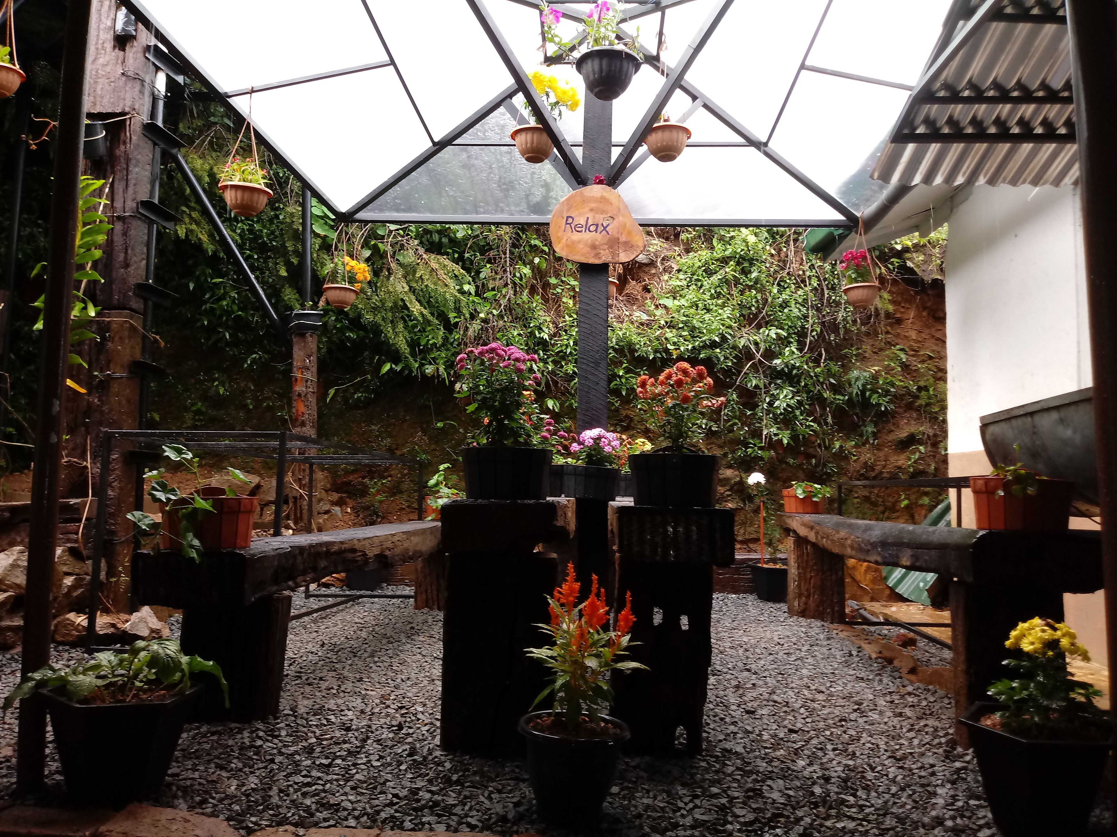 A greenhouse with various potted plants and a sign that reads "Relax".