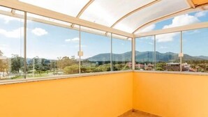 Habitació amb grans finestres i vistes a un paisatge de muntanya.