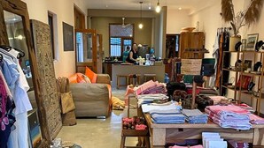 Interior espacioso de un hotel boutique con un comedor central, una cocina a la vista y una variedad de textiles y prendas de vestir ordenadas.