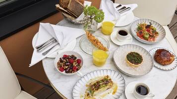 A table with breakfast items including bread, fruit, and a dessert.