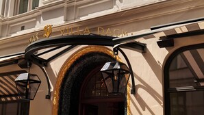 The entrance to Villa Dagmara with a gold sign and black lanterns. - Villa Dagmar (Stockholm)