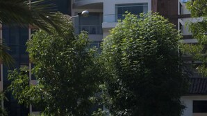 A multi-story building with balconies, surrounded by trees and a clear sky. - Parque 5 Apart Hotel (Cusco)