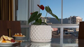 A dining table with fruit and a potted plant. - Parque 5 Apart Hotel (Cusco)