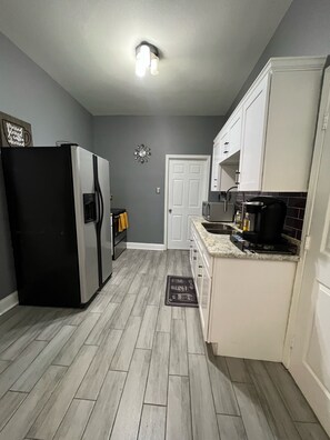 Compact kitchen with a refrigerator, microwave, and coffee maker.