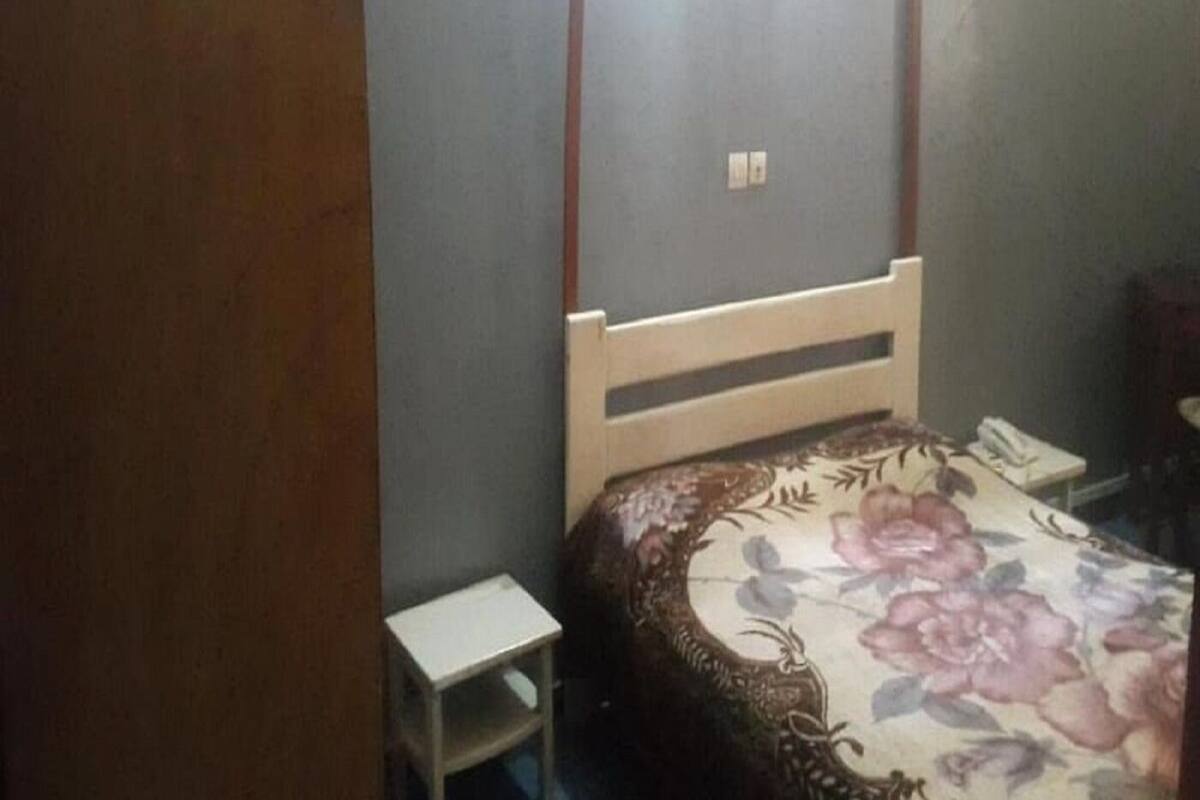 Un dormitorio con cama, mesita de noche y armario.
